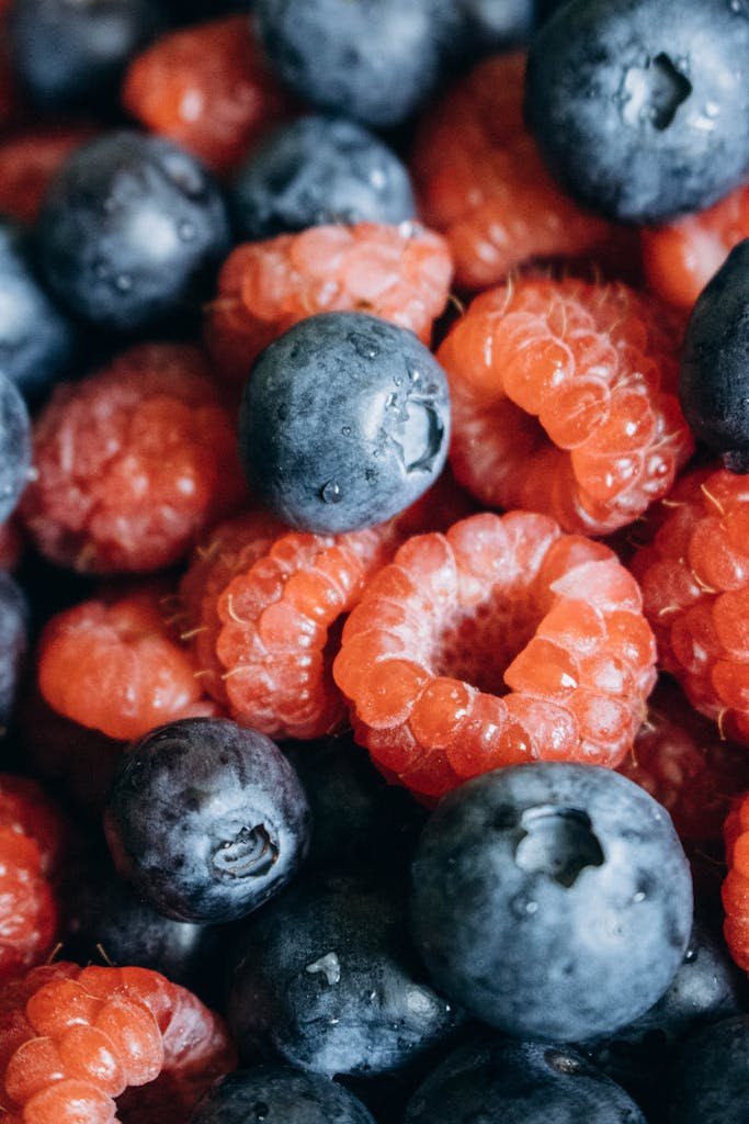 Close-up view of fresh blueberries and raspberries, highlighting their vibrant colors and textures.