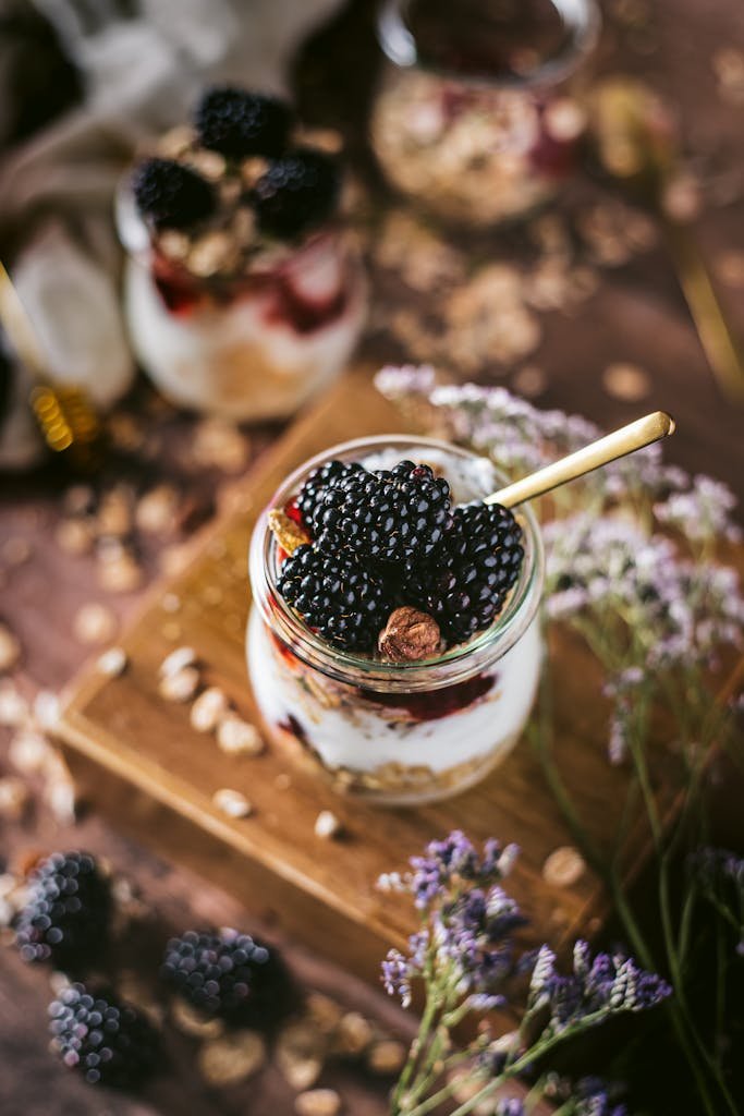 Delicious blackberry yogurt parfait with granola served in a glass jar.