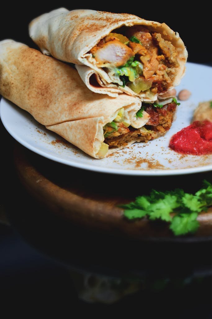 Delicious chicken wrap with herbs and spices, served with tomato sauce on a plate.