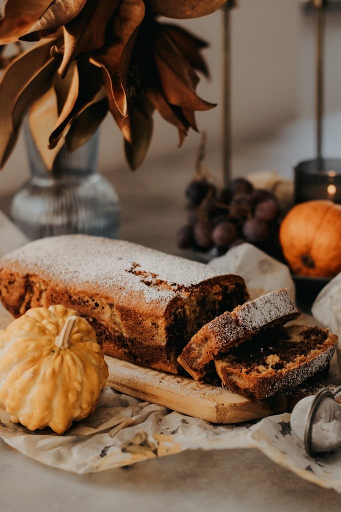 A rustic autumn setting featuring pumpkin bread with cozy seasonal decor.
